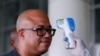 Dr. Chikwe Ihekweazu, the Director General of the Nigeria Centre for Disease Control (NCDC) has his temperature checked during a diplomatic meeting at the Ministry of Foreign Affairs in Abuja, Nigeria on March 12, 2020. 