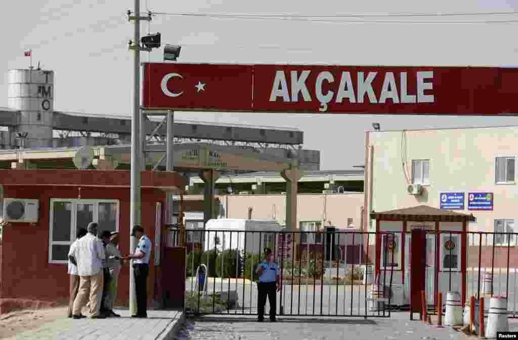 A Turkish police officer checks identification cards of Syrian men after they crossed from Syria to Turkey at the Akcakale border gate, October 4, 2012.