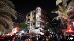Palestinians gather in front of a building as firefighters extinguish a blaze that broke out in one of the apartments in the Jabaliya refugee camp in the northern Gaza strip, Nov. 17, 2022.