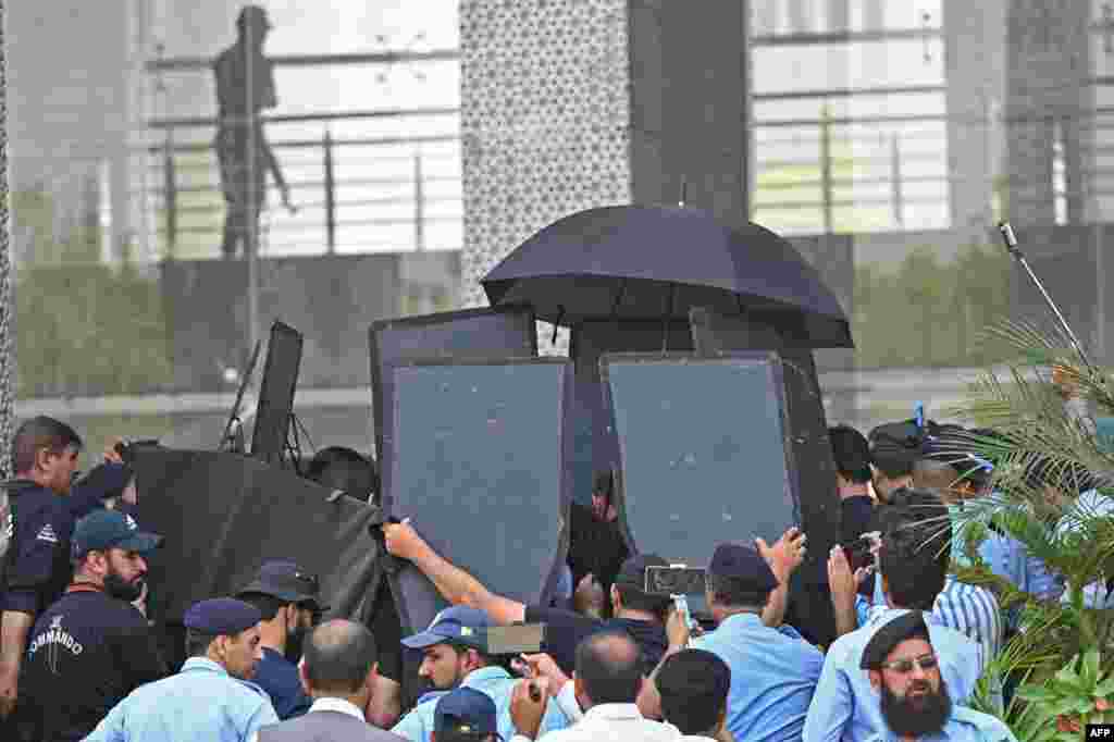 Security personnel with ballistic shields escort former Pakistan's prime minister Imran Khan, at the High Court in Islamabad.