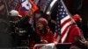 Los partidarios Donald Trump sostienen banderas, luego de que un gran jurado de Manhattan acusara al expresidente tras una investigación sobre el dinero pagado para silenciar a la estrella porno, en la ciudad de Nueva York, EEUU, el 3 de abril de 2023.