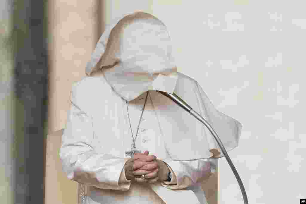 A gust of wind blows Pope Francis's mantle as he stands during his weekly general audience in St. Peter's Square at The Vatican.