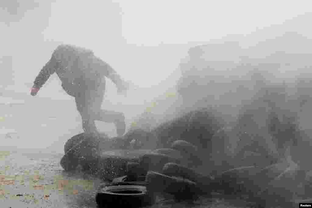 A farmer runs as he is sprayed by a water cannon during a protest of European farmers over price pressures, taxes and green regulation, on the day of an EU Agriculture Ministers meeting in Brussels, Belgium.