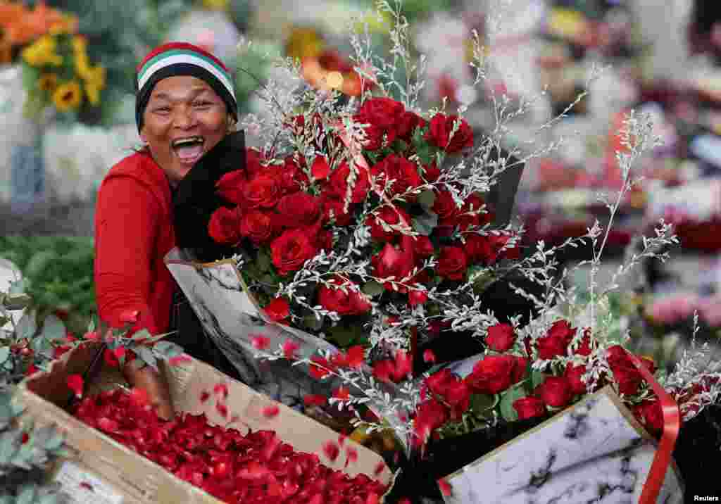 A vendor reacts as she poses for a photo at Adderley Street Flower Market on Valentine's Day in Cape Town, South Africa.