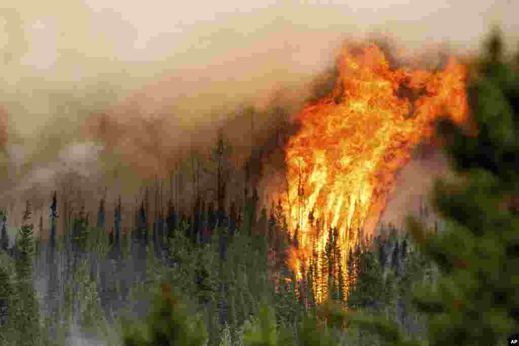 Flames from the Donnie Creek wildfire burn along a ridge top north of Fort St. John, British Columbia, Canada, July 2, 2023.