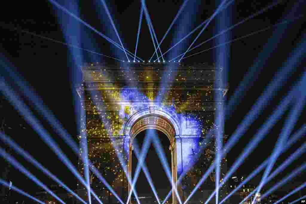 A light show is projected on the Arc de Triomphe during a New Year's celebration on the Champs Elysees in Paris, France, Jan. 1, 2024.
