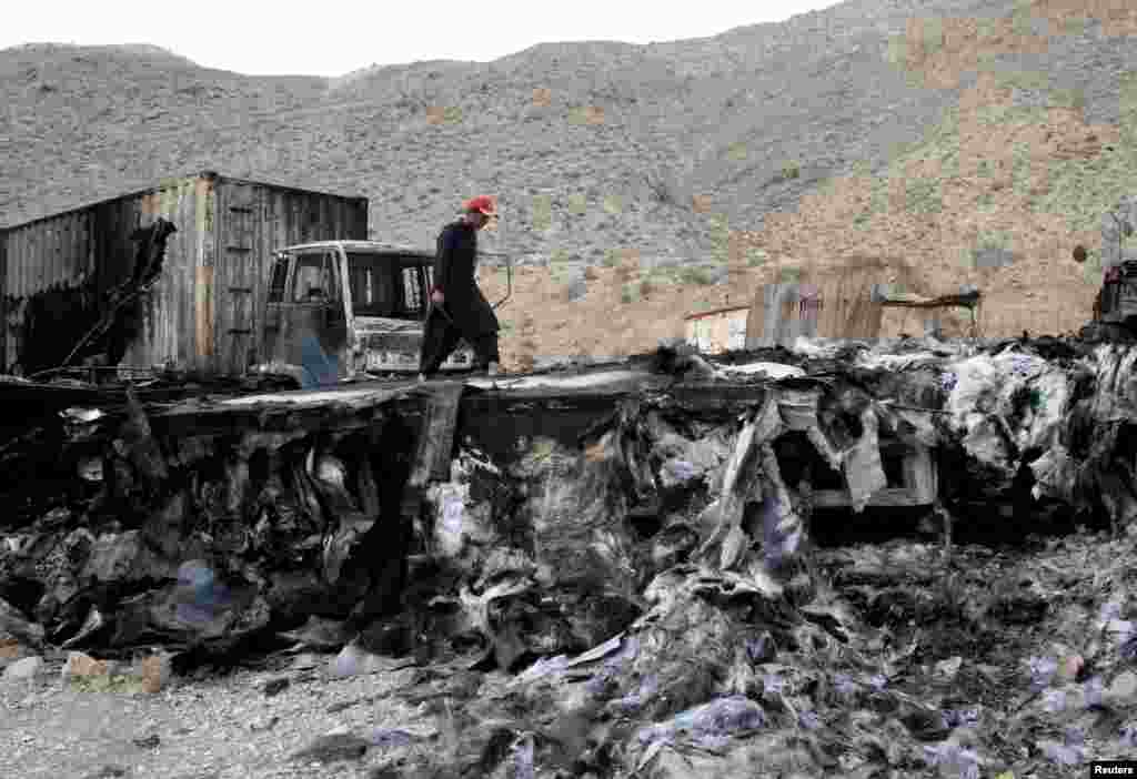 A man walks on a damaged truck trailer after an attack by unidentified armed men in Kolpur, near Quetta, Pakistan.