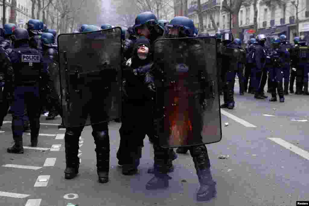 French gendarmes apprehend a protester during clashes on the tenth day of nationwide strikes and protests against French government's pension reform, in Paris.
