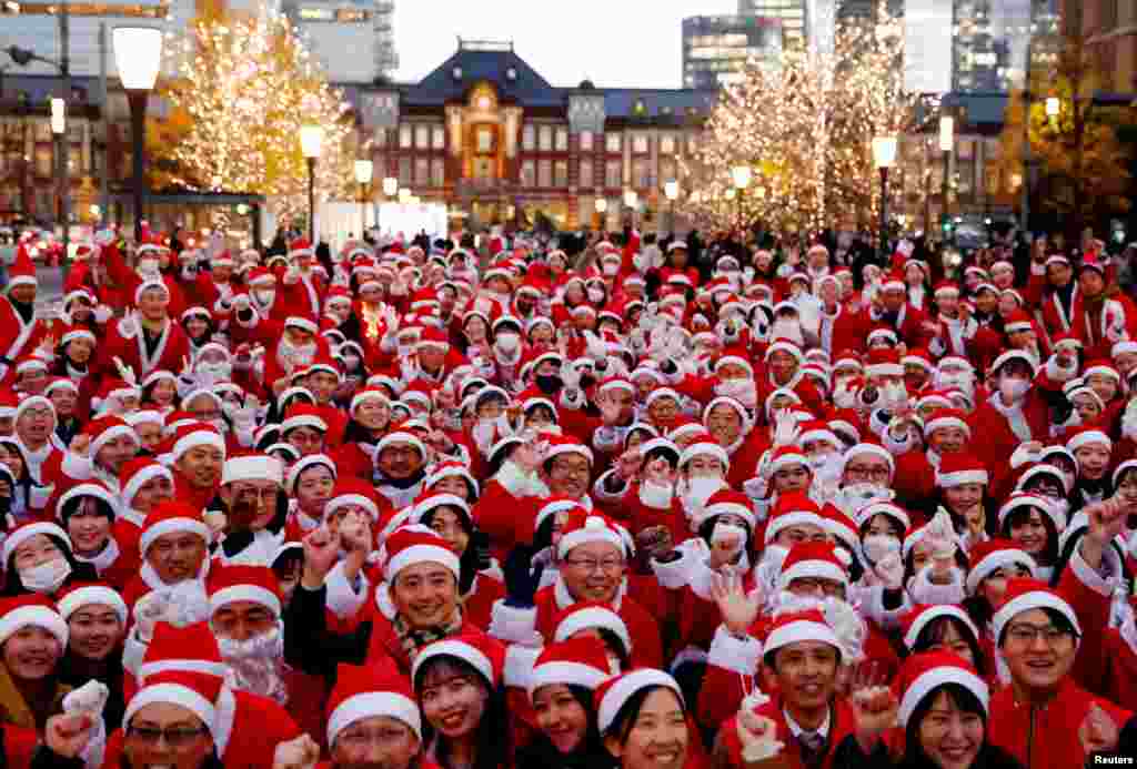Participants wearing Santa Claus outfits pose for photos before their event to hand out gifts and clean up the street to celebrate the upcoming Christmas season in Tokyo, Japan.