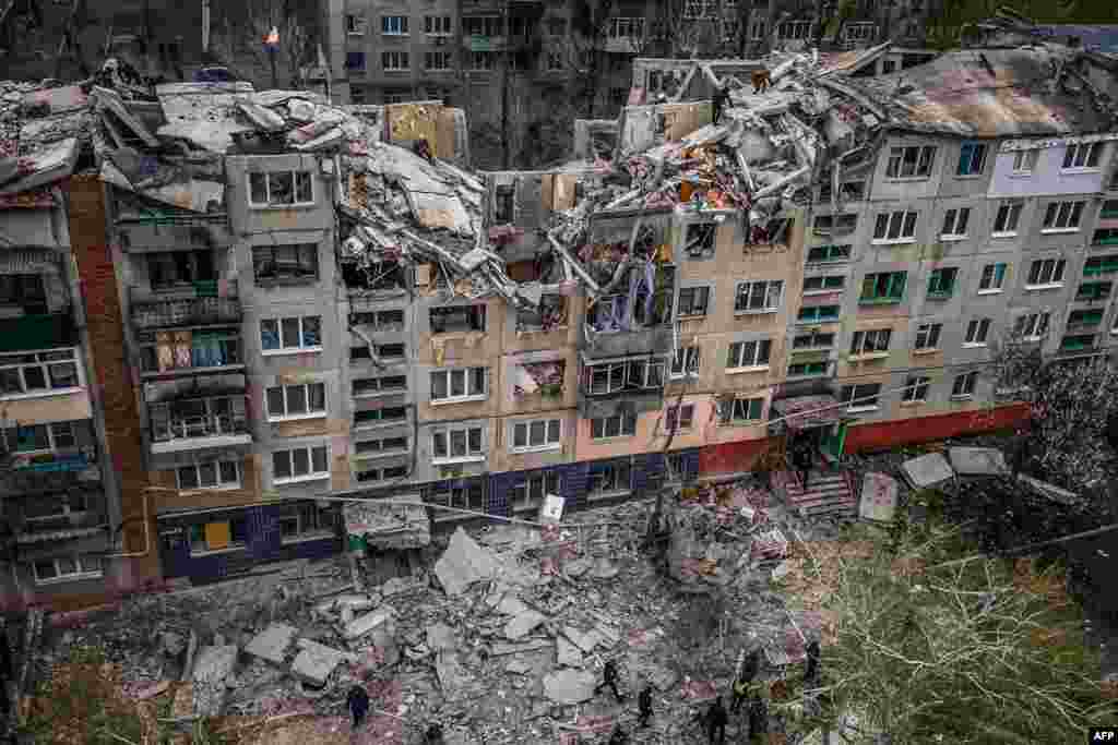 This aerial view shows rescuers on top of a partially destroyed residential building, after a shelling in Sloviansk, amid Russia's military invasion on Ukraine.