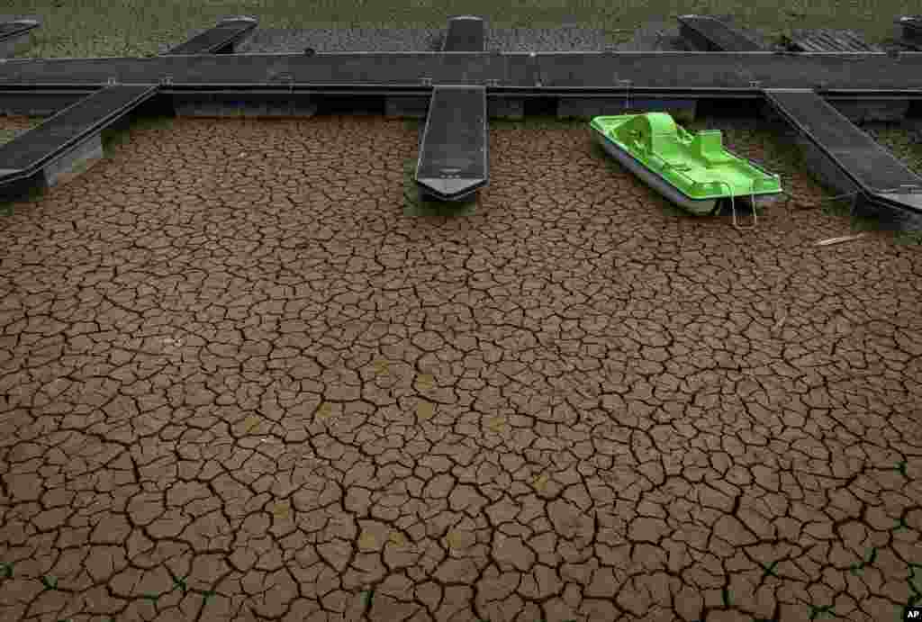 A green pedal boat is tied to a dock in a dried part of the Sau reservoir, about 100 km (62 miles) north of Barcelona, Spain.