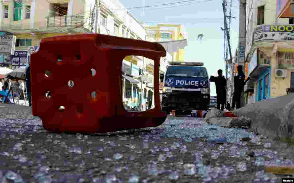 Somali police officers stand guard at the scene after an explosion at the Bakara market in Mogadishu.