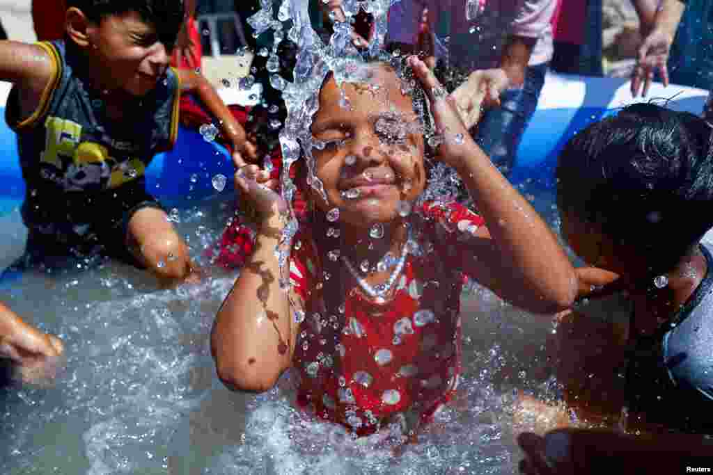A Palestinians girl swims in a swimming pool to cool down amid a heatwave as Gaza power shortages worsened by the heat, provoking protests, in Khan Younis in the southern Gaza Strip, July 17, 2023.