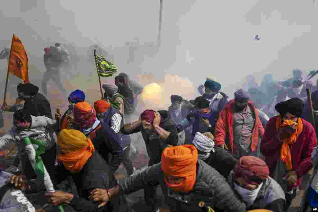 Protesting farmers run away from exploding tear gas shells used by the police near Shambhu border that divides northern Punjab and Haryana states, some 200 kilometers (120 miles) from New Delhi, India.