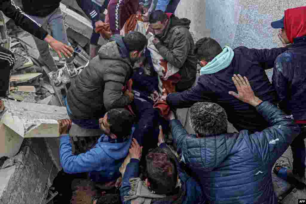 Palestinians evacuate the body of a boy from the rubble of a house destroyed in an overnight Israeli airstrike in east Khan Yunis in the southern Gaza Strip.