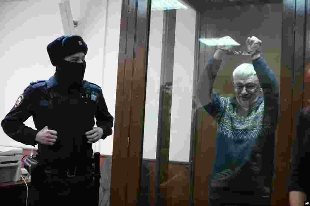 The co-chair of the Nobel Peace Prize winning Memorial Human Rights Centre Oleg Orlov gestures in a glass cage during court session for a new trial on charges of repeated discrediting Russian military, in Moscow, Russia.