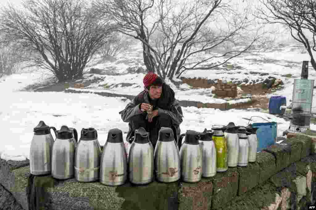 A tea vendor waits for customers along the snow laden Qargha lakeside on the outskirts of Kabul, Afghanistan.