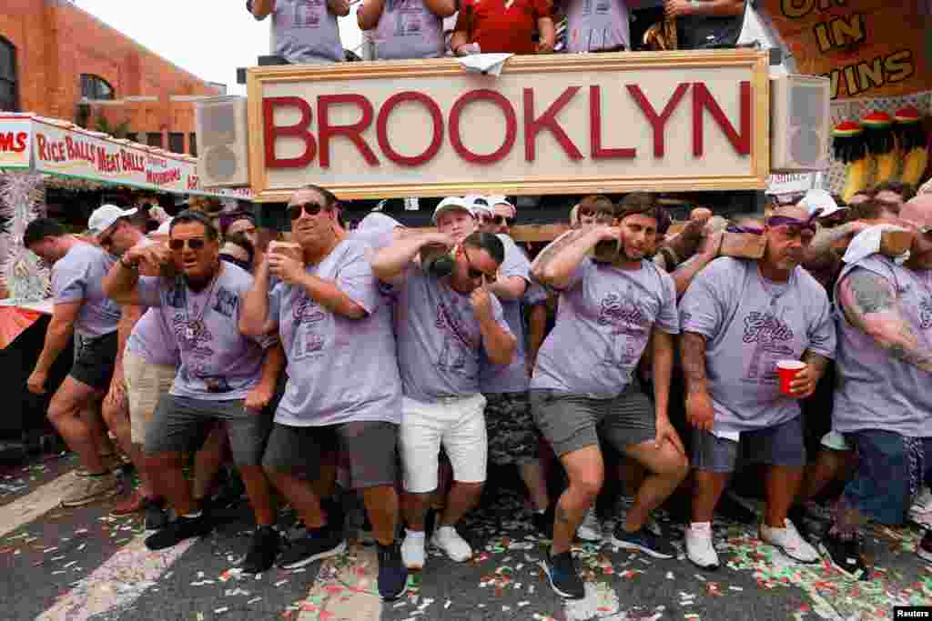People lift a replica of a boat during the Our Lady of Mount Carmel feast in Brooklyn's neighborhood of Williamsburg, New York City, July 9, 2023.