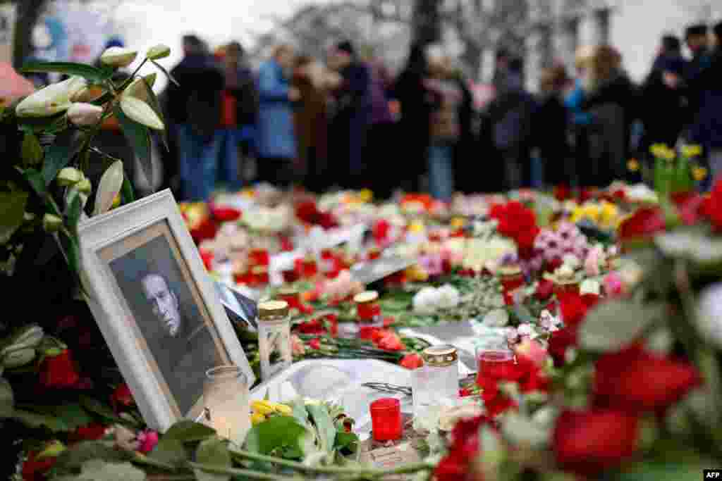People lay flowers and candles at a memorial in front of the Russian embassy in Berlin, Germany, following the death of the Kremlin's most prominent critic Alexei Navalny in an Arctic prison.