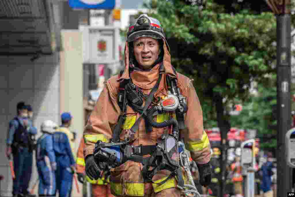 A firefighter works outside of a building where an explosion and a fire broke out in Shimbashi area of Tokyo, Japan. Four people were injured and officials are investigating the cause of the fire.