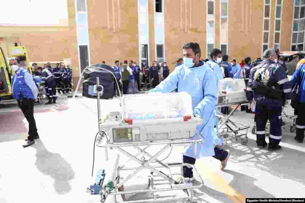 Medics transfer premature Palestinian babies evacuated from Gaza to ambulances on the Egyptian side of the Rafah border.