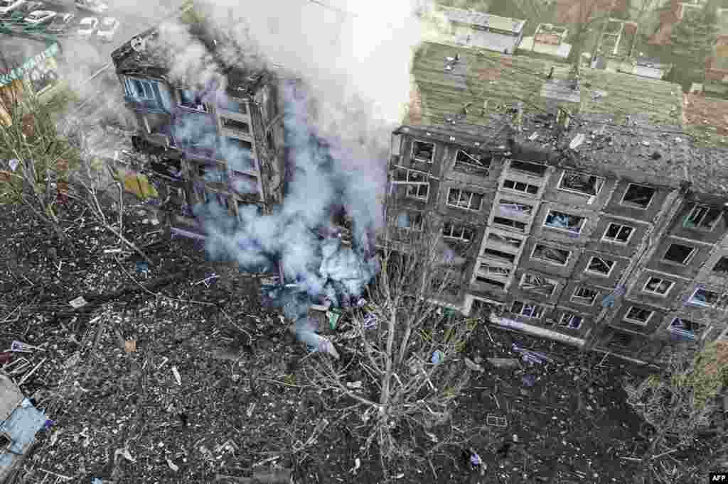 This handout photograph taken and released by National Police of Ukraine shows rescuers extinguish a fire in a residential building following a missile attack in Selydove, Donetsk region. 