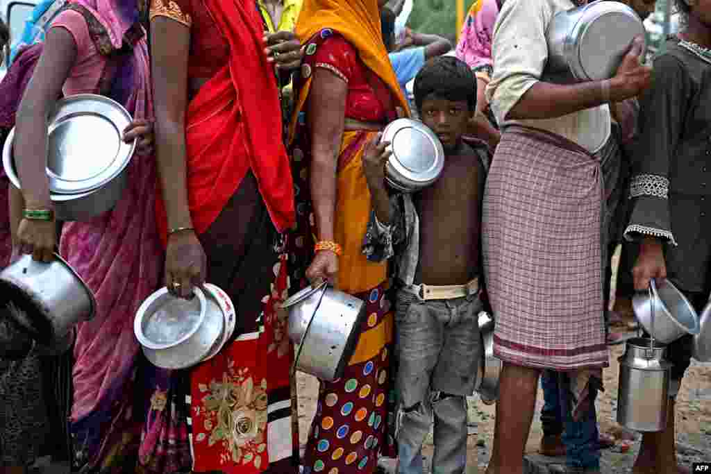 A child stands in a queue to receive food at a temporary shelter after the Yamuna River flooded its banks after heavy monsoon rains in New Delhi, India.