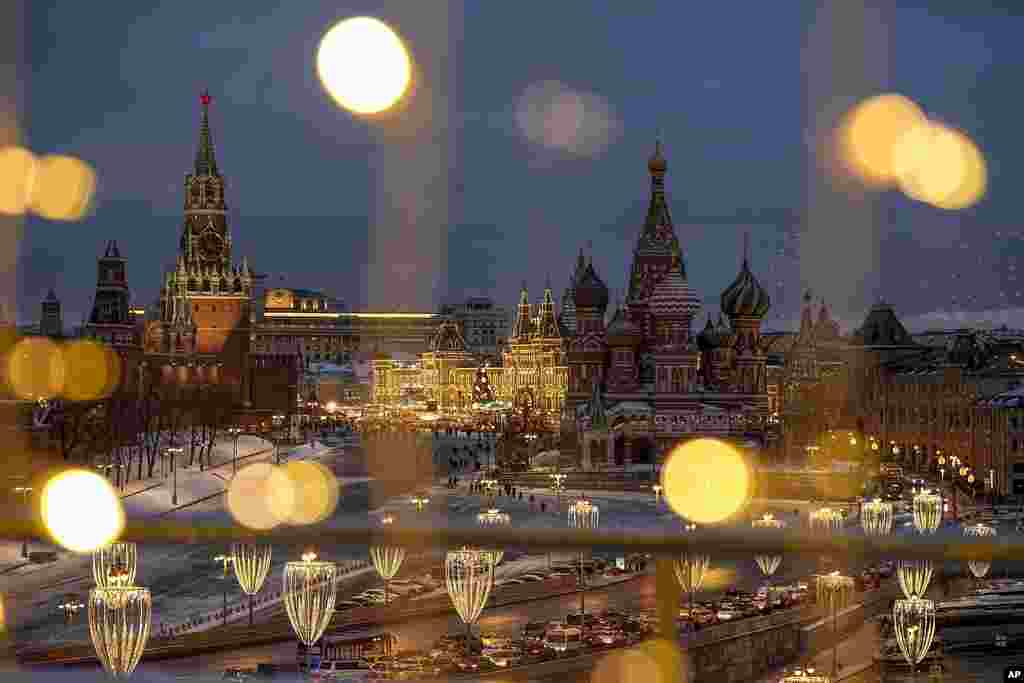 The Spasskaya Tower, Red Square, the GUM department store and the St. Basil's Cathedral are decorated for the New Year and Christmas festivities, as seen though a window of the Hotel Baltschug Kempinski Moscow, in Moscow, Russia.