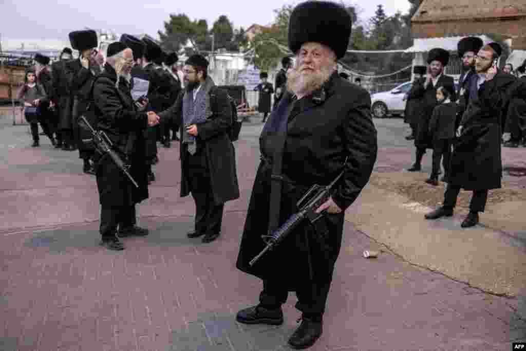 Armed with M16 automatic guns, Ultra-orthodox Jewish men of the Ger Hasidic dynasty and part of the first-response tactical team of their community stand guard during a wedding event in Jerusalem.