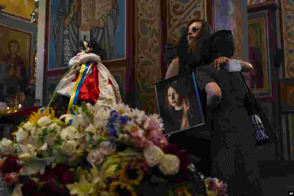Sofia Cheliak hugs a woman during a memorial service for Ukrainian writer Victoria Amelina in Kyiv. The award-winning writer died from her injuries after the June 27 Russian missile strike on a popular restaurant frequented by journalists and aid workers in eastern Ukraine.