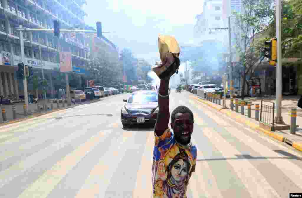 An activists reacts after riot police officers lobbed teargas canisters to disperse them, during a march to call on lawmakers to reject the finance bill proposed by the government that would raise taxes across the economy, along Harambee avenue in downtown Nairobi, Kenya. 