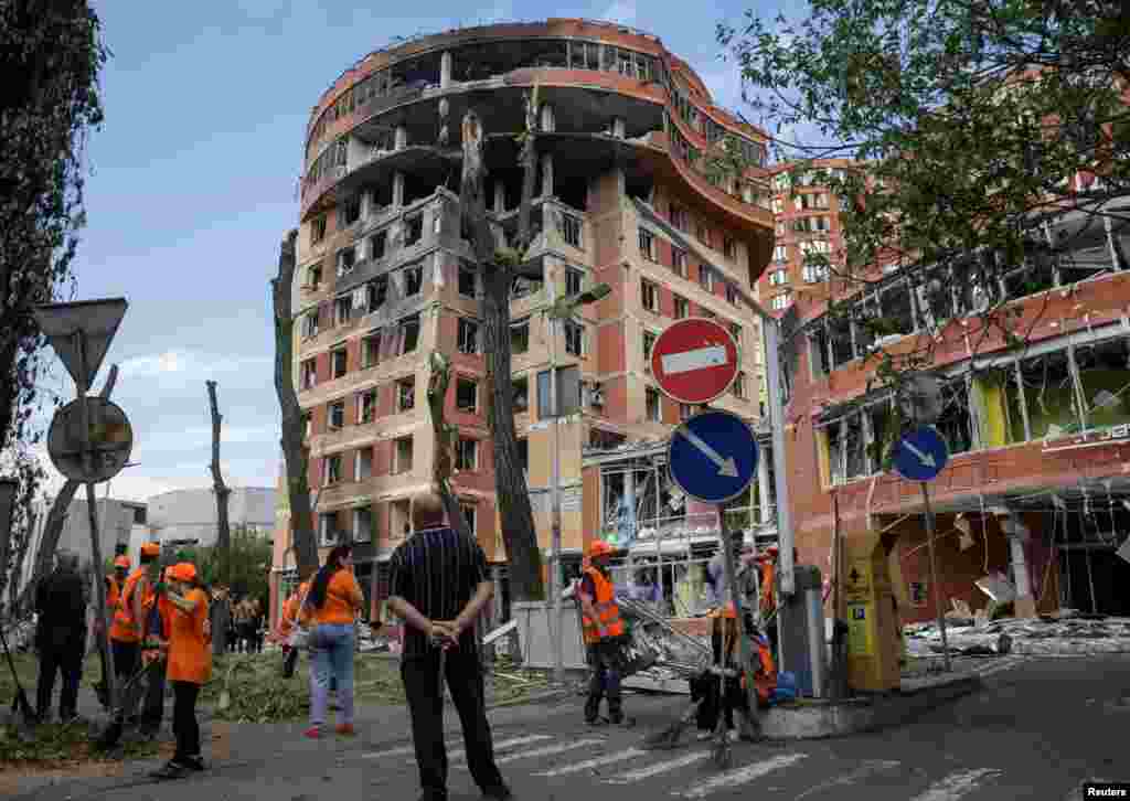 Municipal workers clear debris at the scene of a building damaged by a Russian missile strike in Odesa, Ukraine.