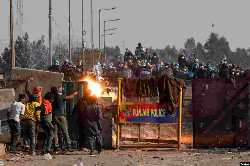 Farmers confront the police as they march towards New Delhi to press for better crop prices promised to them in 2021, at Shambhu, a border crossing between Punjab and Haryana states, India.