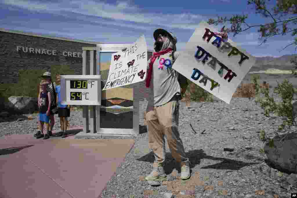 A demonstrator protests visitors to Death Valley National Park, July 16, 2023, in Death Valley National Park, California. Death Valley's brutal temperatures come amid a blistering stretch of hot weather that has put roughly one-third of Americans under some type of heat advisory, watch or warning.
