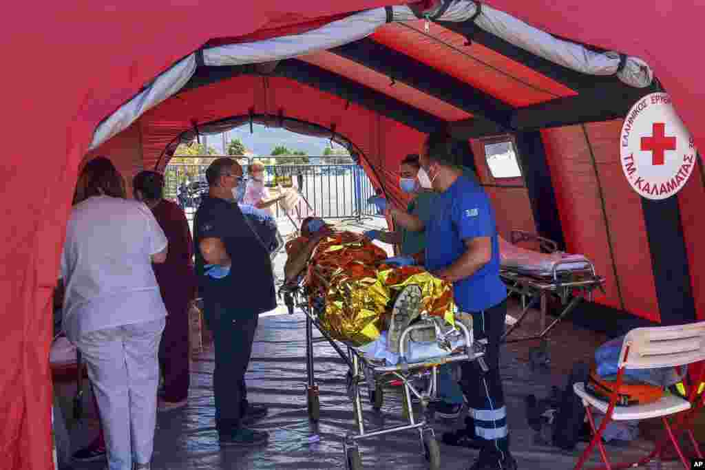 A survivor receives first aid after a rescue operation at the port in Kalamata, about 240 kilometers southwest of Athens, Greece. Authorities say at least 70 people have died and dozens are feared missing off the coast of southern Greece after a fishing boat carrying migrants capsized and sank.