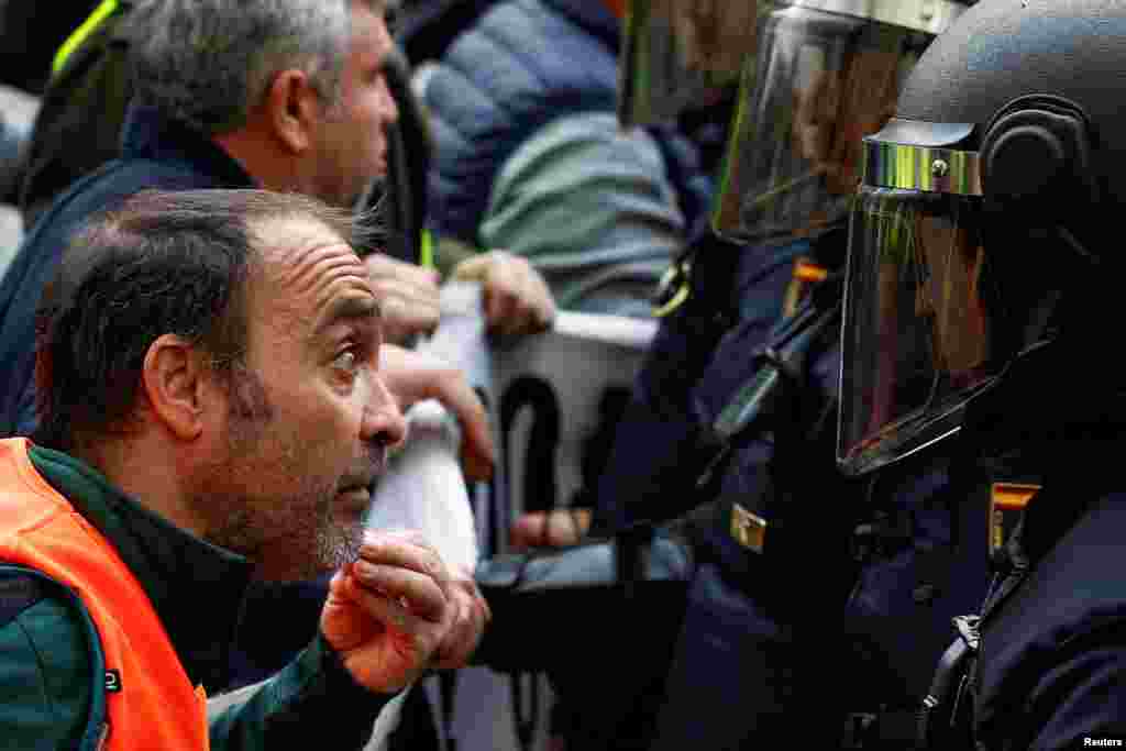 A protester confronts a police officer as farmers protest over price pressures, taxes and green regulation, grievances shared by farmers across Europe, in Madrid, Spain.