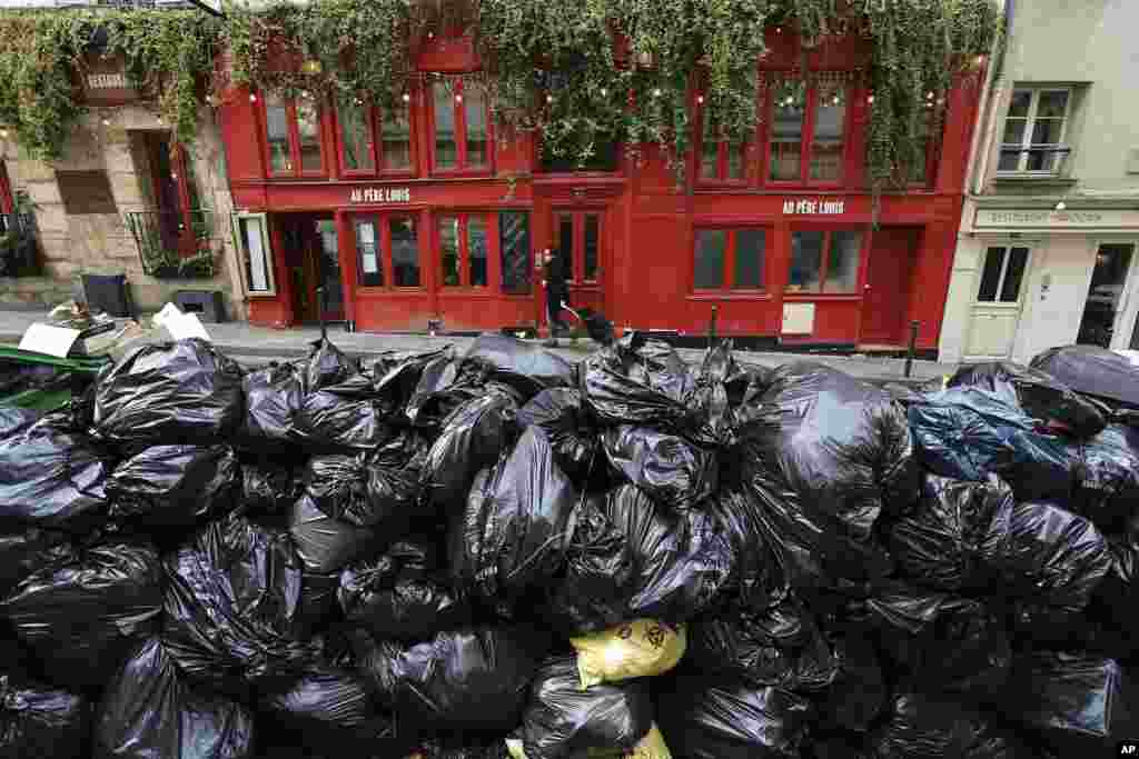 Uncollected garbage is piled up on a street in Paris. France's government is fighting for its survival against no-confidence motions filed by lawmakers who are furious that President Emmanuel Macron used special constitutional powers to force through an unpopular bill raising the retirement age from 62 to 64 without giving them a vote.