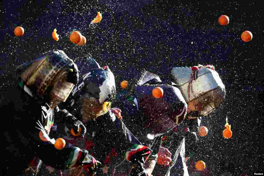 Revelers take part in a fight with oranges during an annual carnival battle in Ivrea, Italy, Feb. 11, 2024.