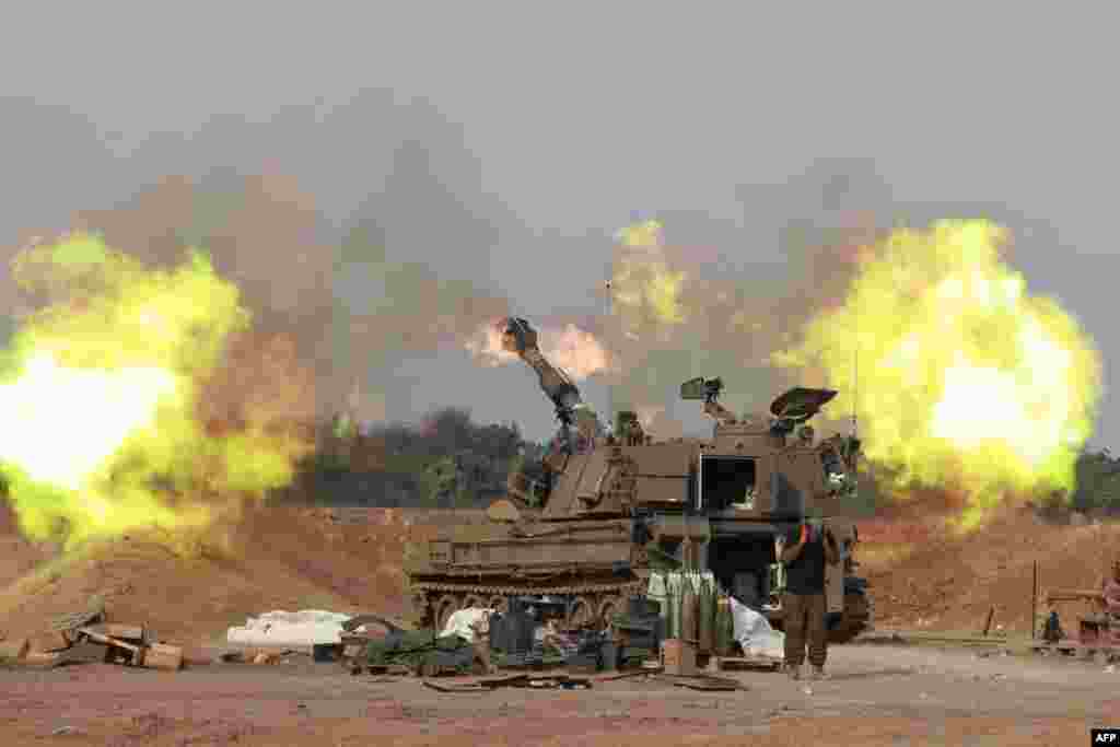 An Israeli army self-propelled artillery howitzer fires rounds from a position near the border with the Gaza Strip in southern Israel amid battles between Israel and Hamas.