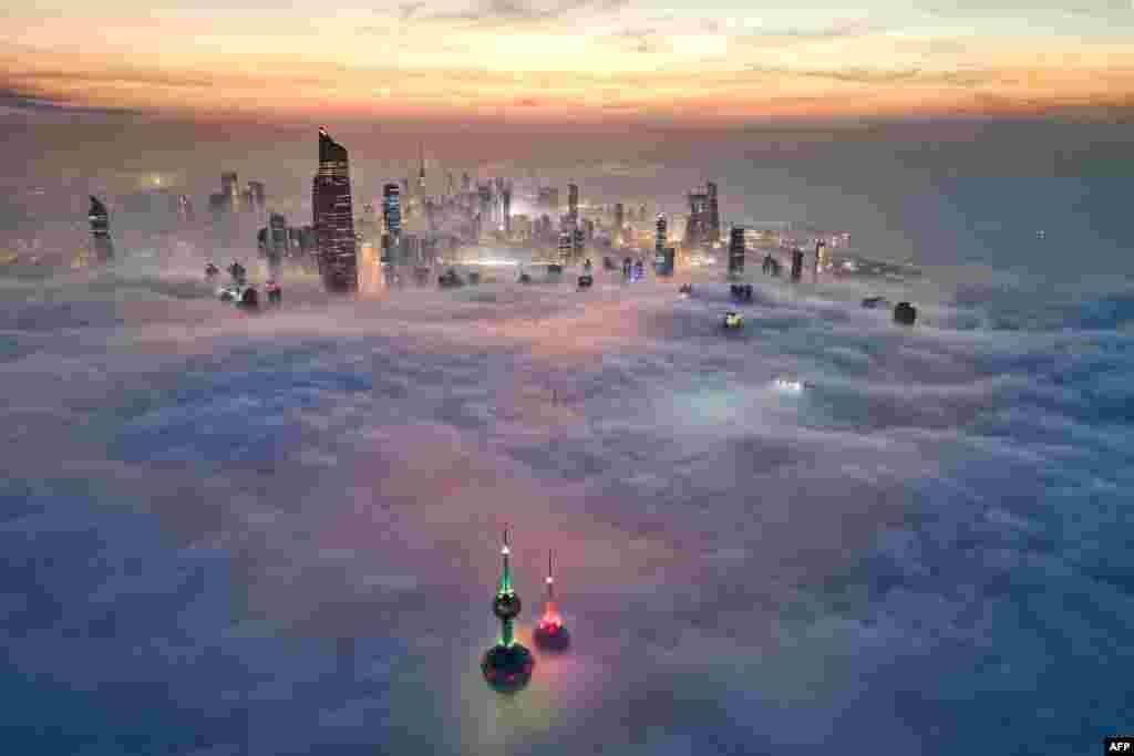 In this aerial view, the landmark Kuwait Towers and other skyscrapers pierce through the cloud cover over Kuwait City.