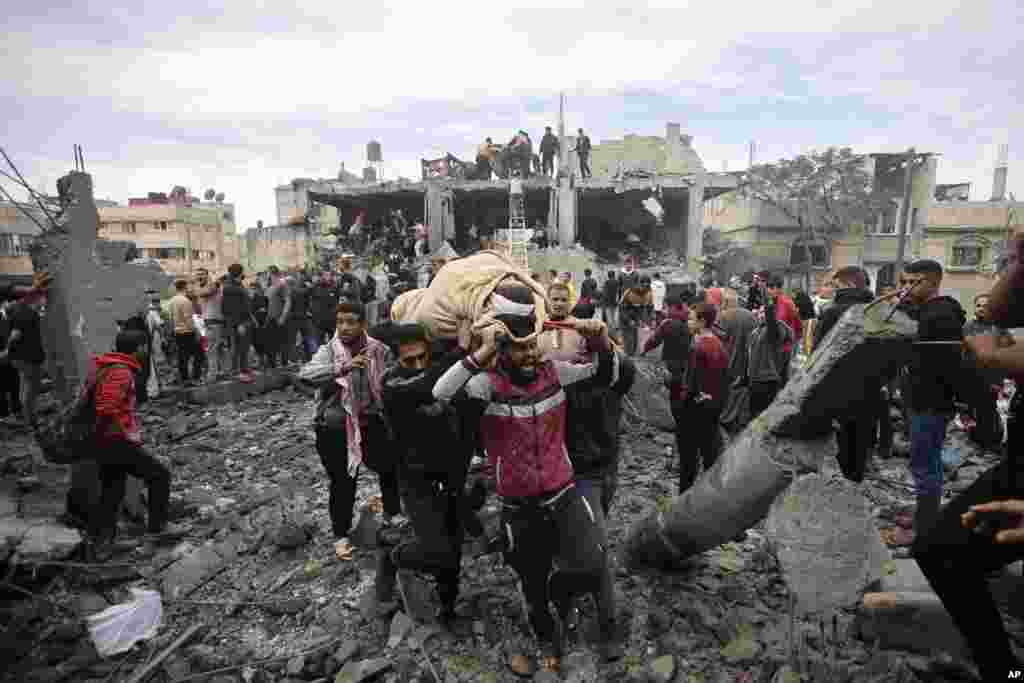Palestinians evacuate a wounded woman following Israeli airstrikes in Khan Younis refugee camp, southern Gaza Strip.