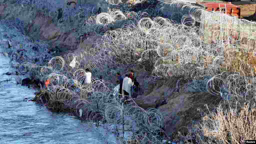 A group of migrants stand on the edge of Rio Grande in Eagle Pass, Texas, Feb. 3, 2024.