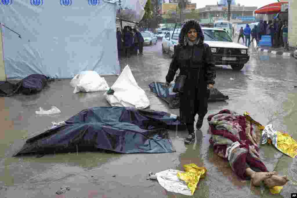 A woman walks between dead bodies of Palestinians killed in the Israeli bombardments of the Gaza Strip, in front of the morgue at Al Aqsa Hospital in Deir al Balah, Gaza Strip.