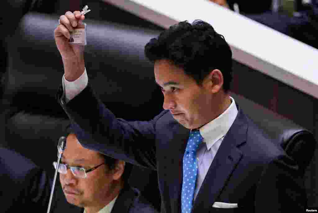 Pita Limjaroenrat, leader of the Move Forward Party, holds up his ID card at parliament after Thailand's Constitutional Court ordered his temporary suspension from the parliament, on the day of the second vote for a new prime minister, in Bangkok. 