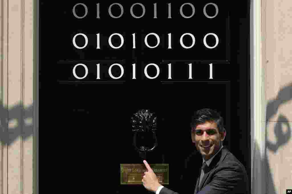 Britain's Prime Minister Rishi Sunak poses by the door of 10 Downing Street, which is adorned with the numbers one and zero that in binary code represent London Tech Week in London.