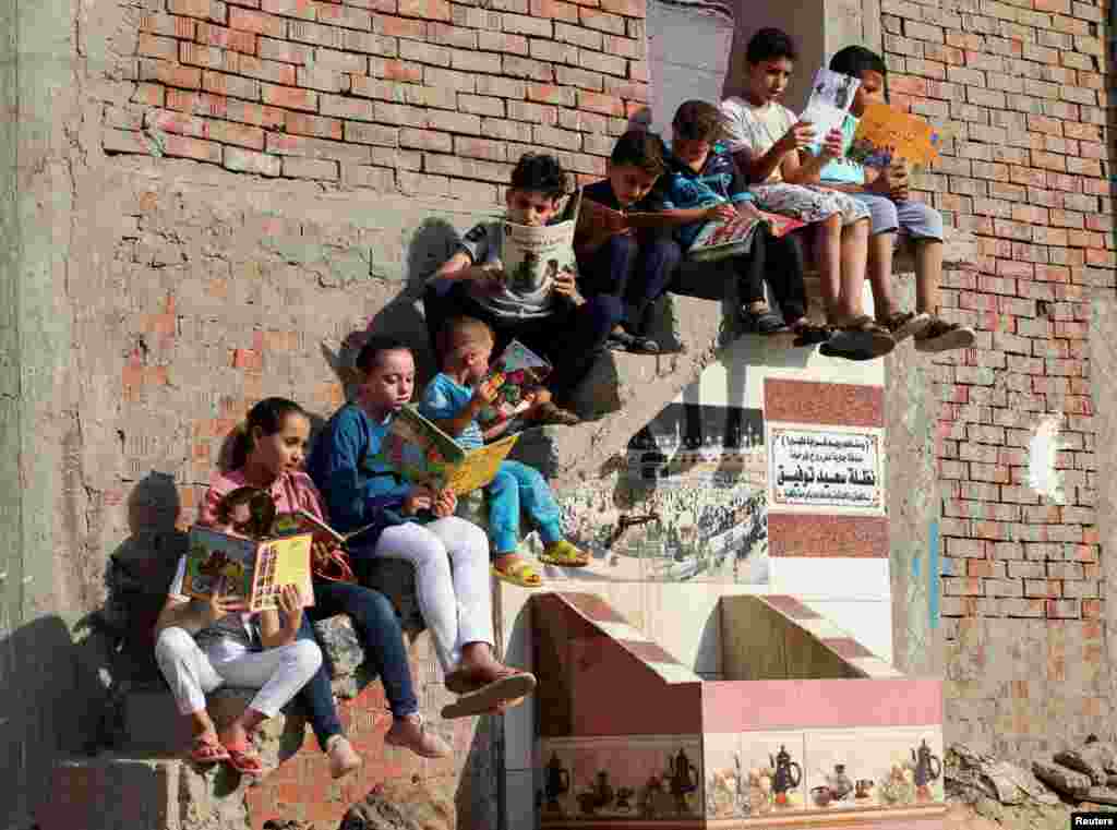 Children read books they borrowed from Mohamed Abdel Aziz's house, which has been turned into a free learning center for village students lacking access to cultural services and activities, at Bishet Amer village in the Sharqia Governorate, north of Cairo, Egypt.