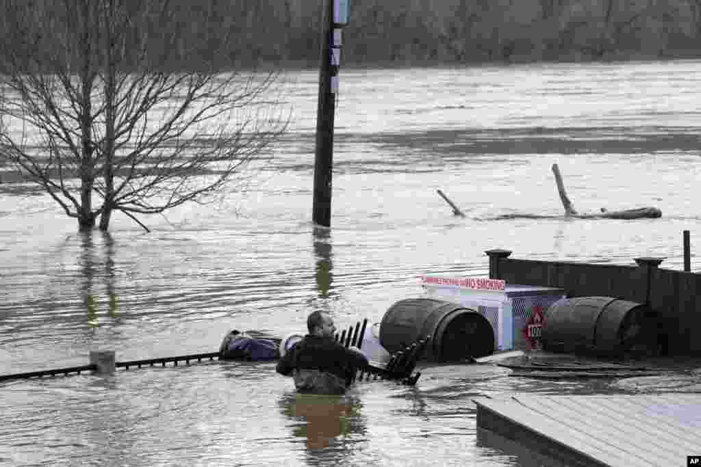Nathan Sennett wades through in hip-deep water on the patio of the Quarry Tap Room in Hallowell, Maine.
