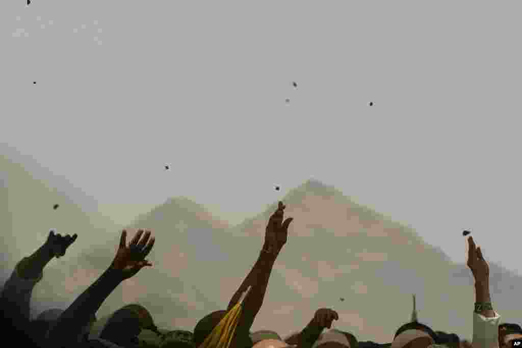 Muslim pilgrims cast stones at pillars in the symbolic stoning of the devil, the last rite of the annual Hajj, in Mina near the holy city of Mecca, Saudi Arabia.