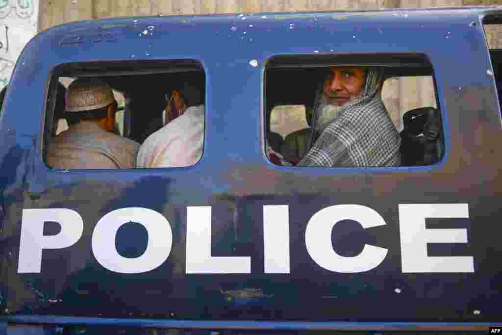 Detained Afghan refugees sit in a van during a search operation to identify alleged illegal immigrants, on the outskirts of Karachi, Pakistan.