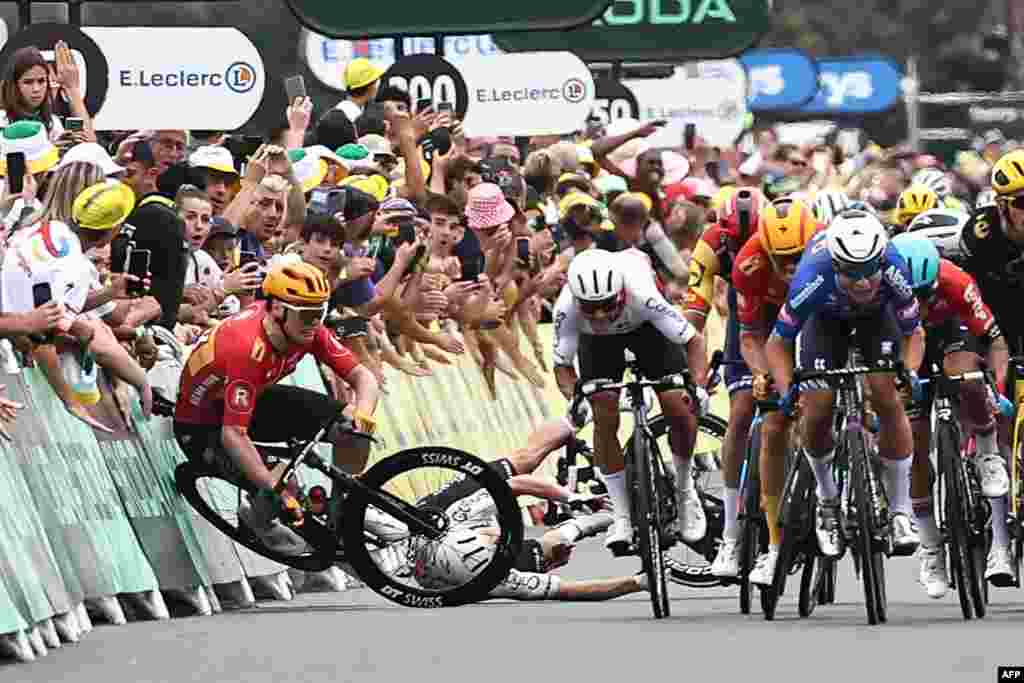 Uno-X Pro Cycling Team's Norwegian rider Soren Waerenskjold (L) crashes as the pack of riders sprint to the finish line during the 4th stage of the 110th edition of the Tour de France cycling race, 182 km between Dax and Nogaro, in southwestern France. 